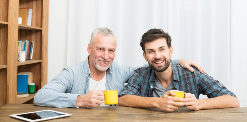 hombre e hijo sentados tomando cafe